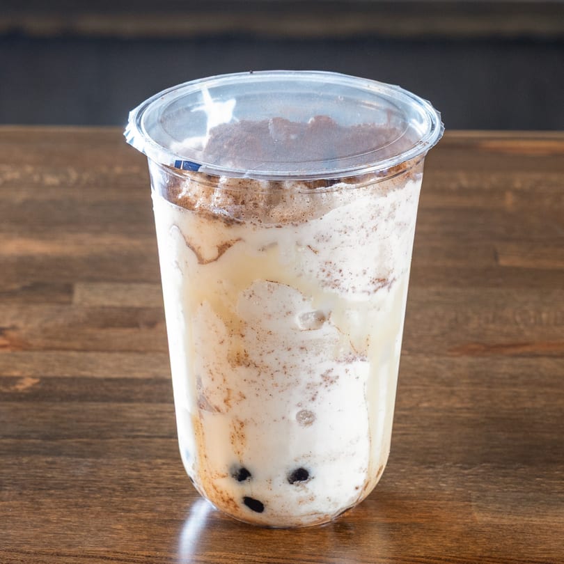 Mexiyaki's Asian-inspired boba tea with dark pearls and a frothy, light brown drink topped with powder.